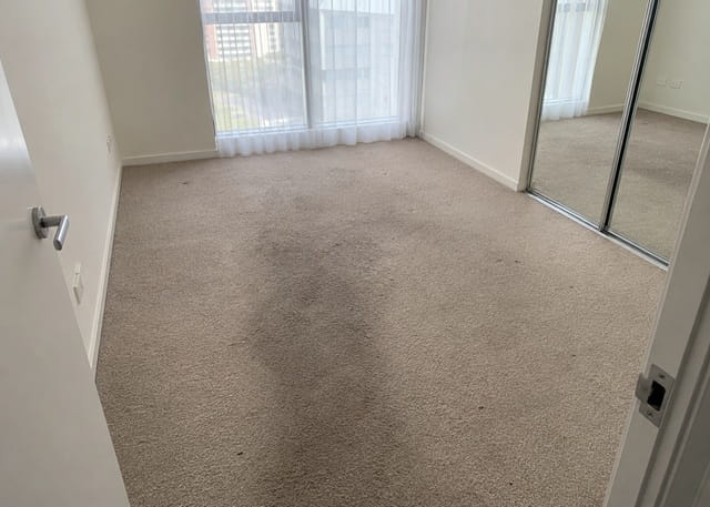 Stained bedroom carpet before end of lease carpet cleaning in a Sydney rental
